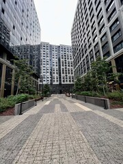 Tall buildings of a new residential complex, viewed from below from the courtyard, concrete jungles on a gray day.