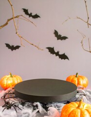 Halloween display pedestal surrounded by pumpkins, faux spider webs, black spiders, paper bats, and decorative bare branches, creating a festive and spooky backdrop for party treats or decorations

