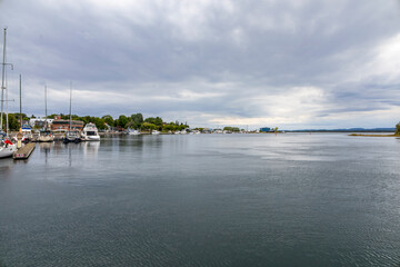 Tranquil waterfront scene at Little Current, Manitoulin Island, featuring the historic swing bridge against a serene sky and calm waters.