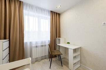A cozy room with a window, brown curtains, and a white desk with a chair