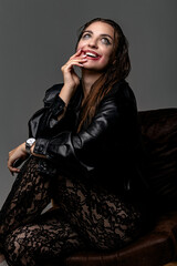 Model enjoys playful moment in stylish black leather jacket and lace pants indoors