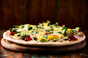 Pizza with chorizo ​​sausage, mozzarella cheese and yellow pepper. Rustic wooden background. Soft focus.	