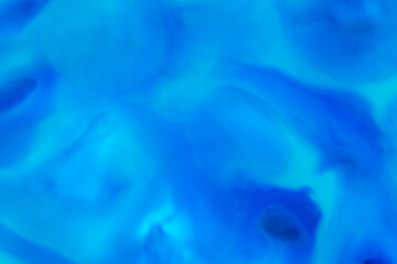 artistic backdrop: close up of mixture of  blue color liquid watercolor paints