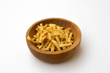 Golden crispy chips with crunchy texture salty tasty snack food in the wooden bowl, isolated on white background