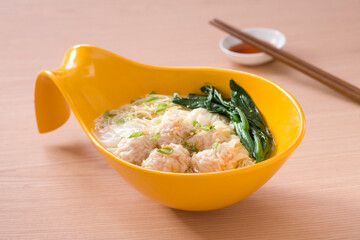 A bowl of Wonton noodles and chopsticks