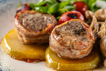 Juicy pork medallions with grilled vegetables and mushrooms