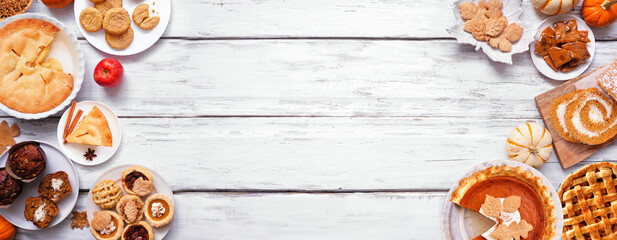 Autumn desserts double border. Table scene with a collection of traditional fall sweet treats. Above view over a white wood banner background. Copy space. Pies, pumpkin roll, muffins, cookies.