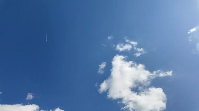 Short video of the sky. Lot of white clouds. Airplane in the sky.

