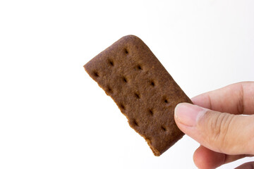 Hand holding a chocolate biscuit on a white background