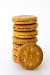 A stack of golden crackers isolated on white background, showcasing their round shape and crispy texture. Perfect for snacking or as an ingredient in various culinary creations
