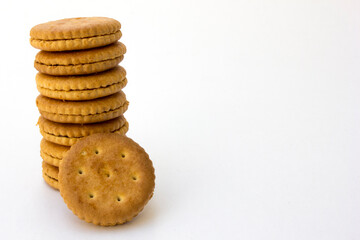 A stack of golden crackers isolated on white background, showcasing their round shape and crispy texture. Perfect for snacking or as an ingredient in various culinary creations