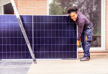 Female worker preparing solar panels for installation on residential house roof