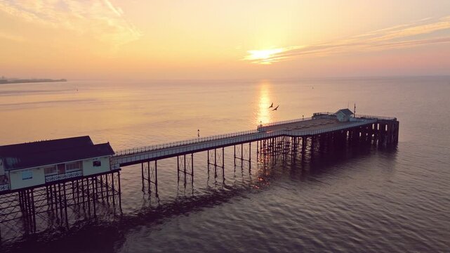 Aerial drone footage of sunrise above Bristol Channel overlooking the Penarth pier.