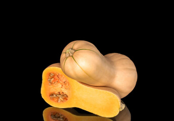 Ripe sweet pumpkins isolated on black background, close-up.