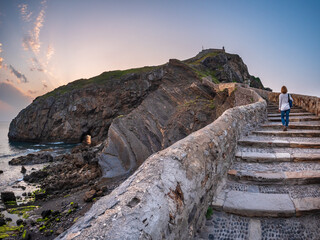 Ancient stone bridge leading to Gaztelugatxe islet at sunset Basque Country Spain symbol of journey solitude spirituality dramatic seascape inspiration