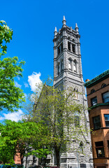 The stone Gothic Revival tower of the historic Emmanuel Baptist Church rises against a bright blue summer sky in Albany, New York, United States