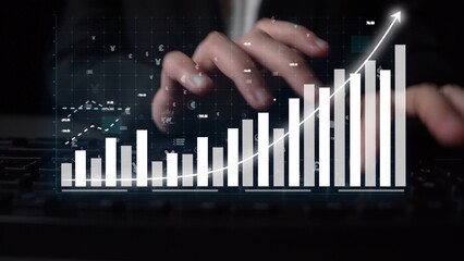 A close-up view of hands typing on a keyboard, alongside a modern digital graph showcasing data trends and analytics in a contemporary workspace setting. Copula