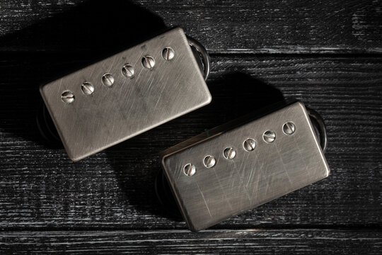 humbucker pickups on black wood background top view