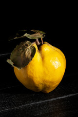 quince on black wood background