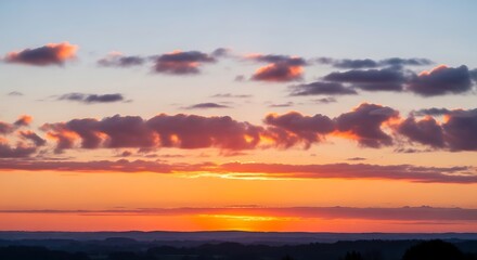 Obraz premium Vibrant sunset paints the sky with fiery hues and dramatic clouds.