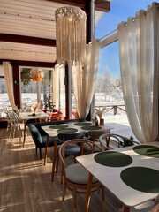 rustic restaurant with panoramic windows in boho style on a snowy landscape background 