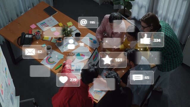 A team of professionals collaborates in a modern office, analyzing charts and data while engaging with various social media engagement icons above them. Raster - Powered by Adobe