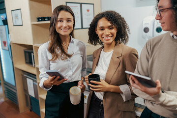 A diverse group of professionals is engaging and collaborating over coffee in a modern office space