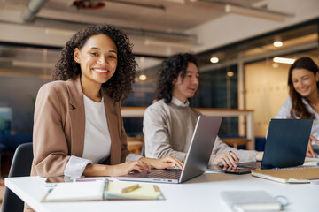 A diverse team of professionals collaborates and shares creative ideas in a vibrant office work setting