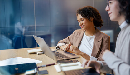 At a contemporary workplace, two skilled professionals are engaged in a fruitful discussion about various topics