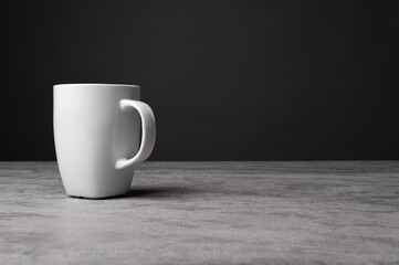 White Ceramic Mug on Grey Table with Dark Background