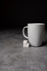 White Coffee Mug with Sugar Cubes on Grey Table