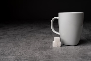 White Coffee Mug with Sugar Cubes on Grey Table