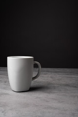 White Ceramic Mug on Grey Table with Dark Background