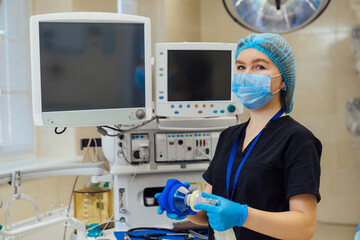 Healthcare staff set up medical equipment. A healthcare worker in scrubs arranges medical equipment...
