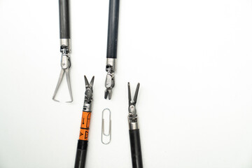 Tools arranged on a white surface for crafting projects. Crafting tools are showcased on a white...