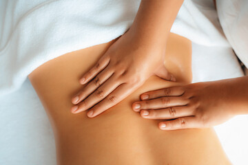 Closeup woman customer enjoying relaxing anti-stress spa massage and pampering with beauty skin recreation leisure in day light ambient salon spa at luxury resort or hotel. Quiescent