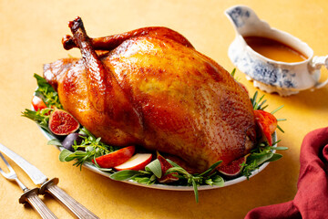 Turkey served with figs and apples. A traditional festive dish. Yellow background. Close up.