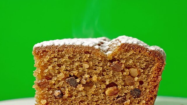 Warm, freshly baked fruitcake dusted with powdered sugar, releasing steam.