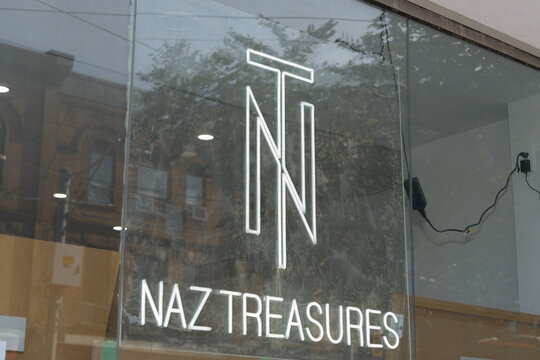 sign inside window at Naz Treasures, a clothing store, located at 717 Queen St E, Toronto