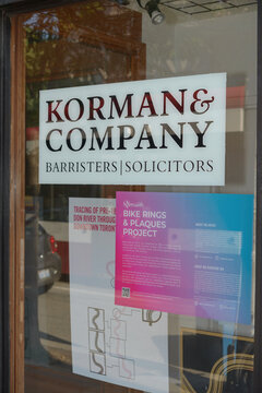 sign inside window at Korman & Company, an Attorney, located at 721 Queen St E, Toronto