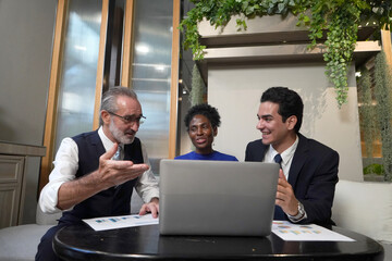 Business people having discussion while collaborating on a new project in an office. Group of happy businesspeople working together in a modern workspace.