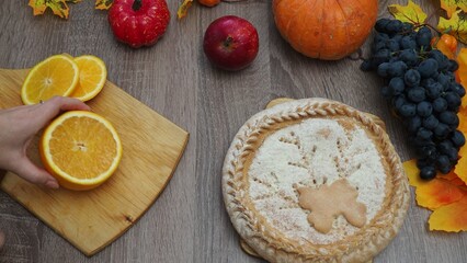 a woman is preparing a festive dinner at home. chicken with oranges. On the table there is pie and fruits, grapes, apples, pumpkin. Roasted Turkey. Thanksgiving table served . Christmas dinner