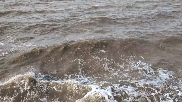 Slow motion video footage showing the force of strong currents and swell creating hazardous dangerous waves that are crashing in a rough sea forming spray and foam.
