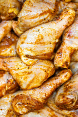 Raw chicken drumsticks seasoned with spices, close-up view. Marinated meat ready for cooking. Culinary preparation, rustic food styling, high-resolution texture detail.