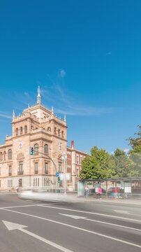 Panorama showing Cavalry Academy timelapse in Plaza de Zorrilla, Valladolid, Spain. Historic military building with intricate architecture, surrounded by busy urban scene under a blue sky with clouds