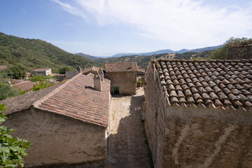 Narrow cobblestone street with rustic stone houses in traditional Sardinian village