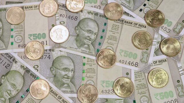 Close up view of brand new five hundred indian rupees (INR) banknotes, coins. Concept of saving money for retirement, cash settlement, financial goals, success, literacy and income planning in India.