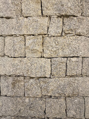 Rustic stone wall with multicolored natural rocks and mortar