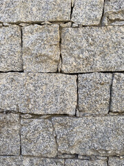 Rustic stone wall with multicolored natural rocks and mortar