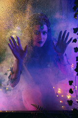 fantasy woman river nymph dark silhouette through wet glass pool with water drops fog smoke. mermaid hands touching glass eyes looking at camera. faerie spirit Gothic girl fairy elf face. neon light